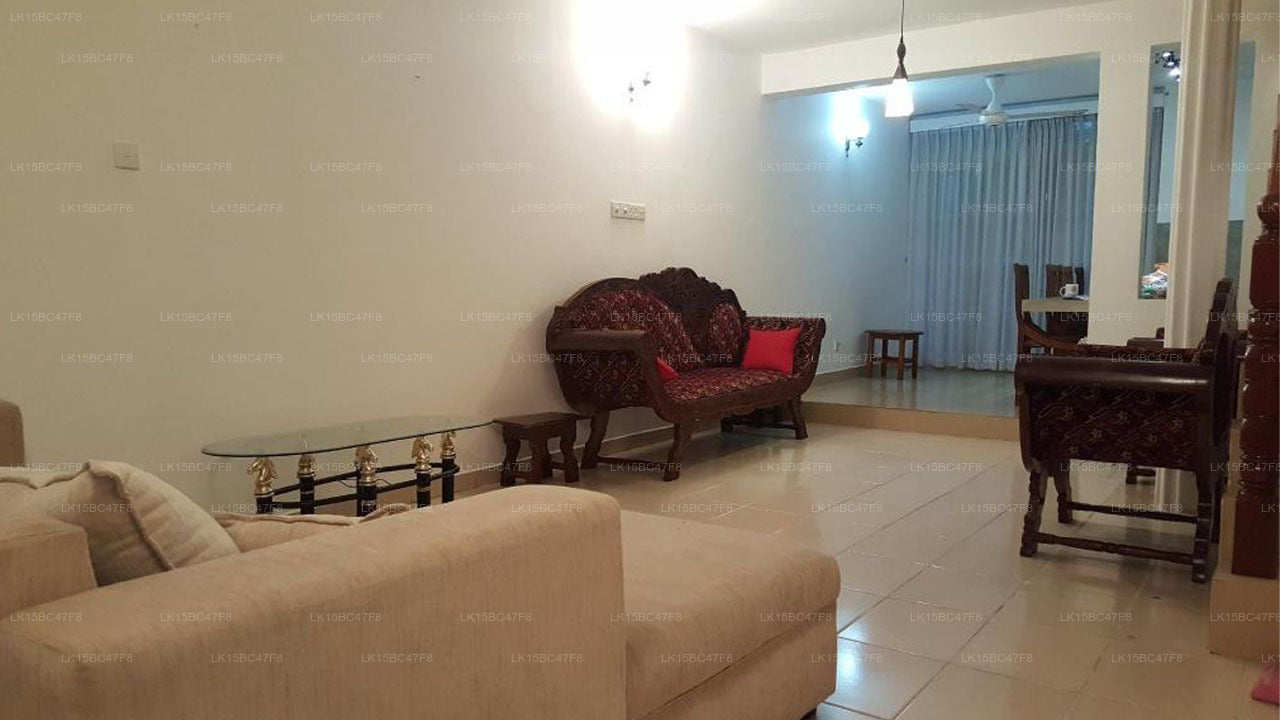 Living room with beige sofa, wooden coffee table, and red sofa set.