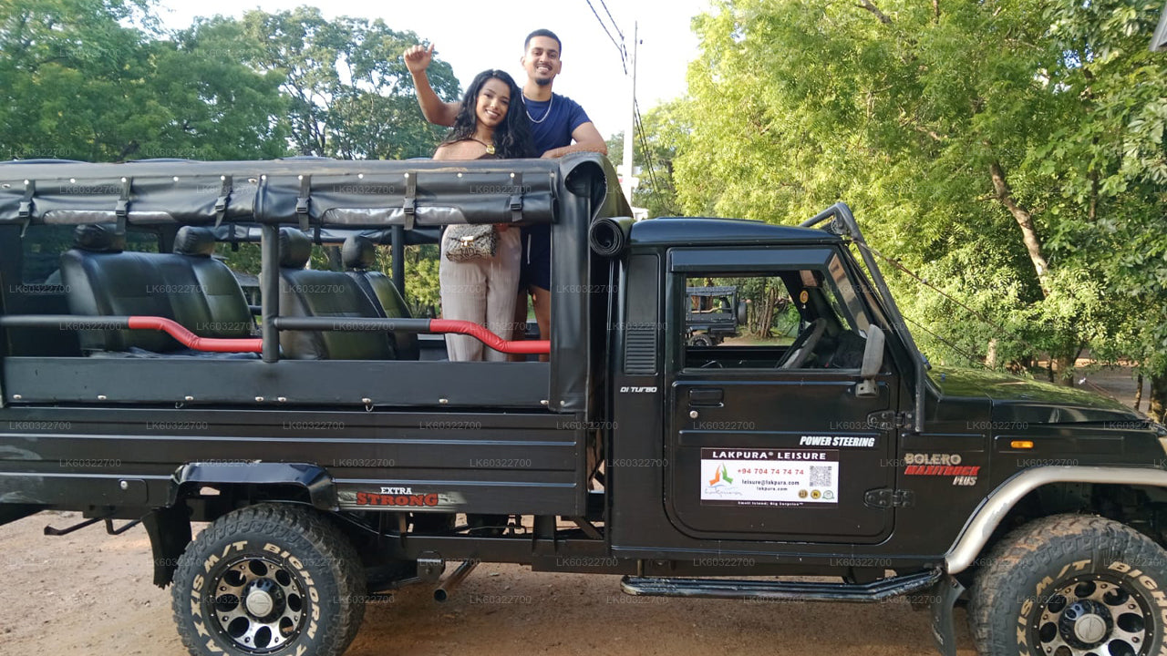 Two people standing on a black off-road vehicle with a forest background