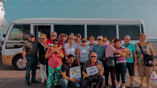 A group of people in front of a tour bus, presumably at the beginning of a trip or tour.